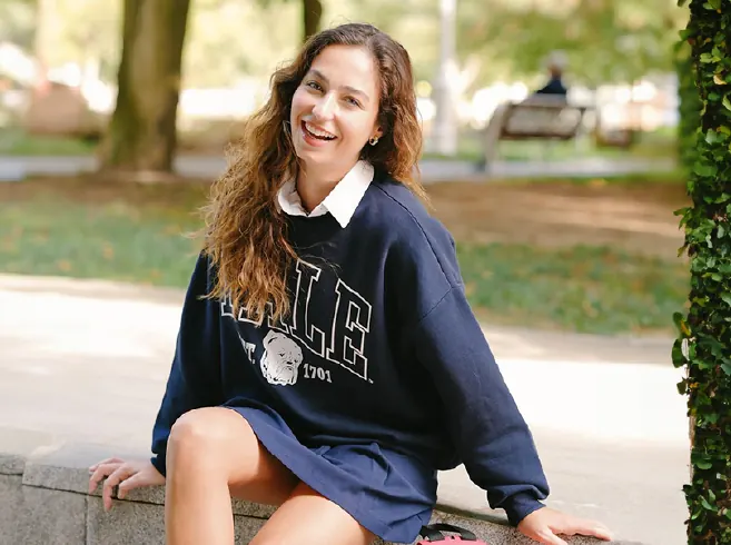 Bayıldım campaign: a smiling woman in a navy sweatshirt sitting in a park